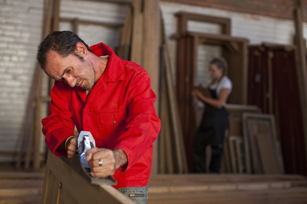 Charpentier au travail utilisant un rabot