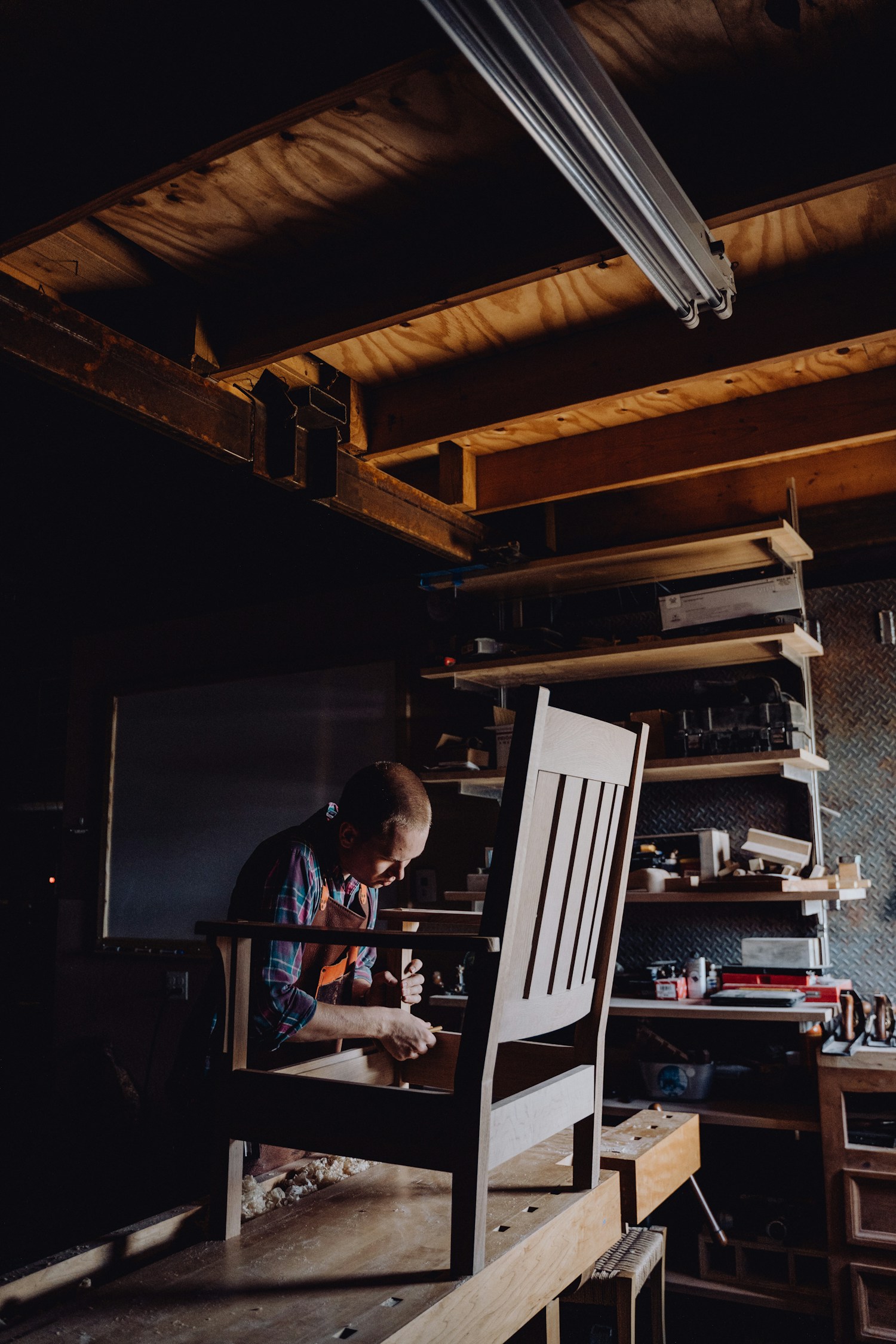 Menuisier assemblant une chaise dans son atelier